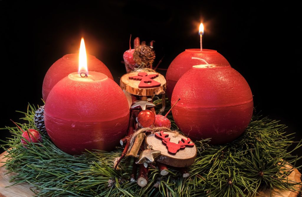 Adventskranz mit Kugelkerzen und Symbolen auf Holzscheiben